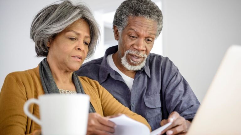 Senior couple working on their finances at home (1)